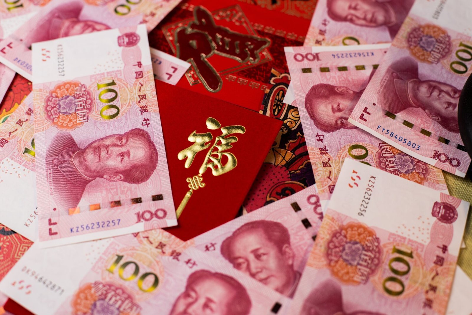 A closeup shot of 100 Chinese Yuan (CNY) banknotes and Chinese traditional red envelop for Chinese New Year