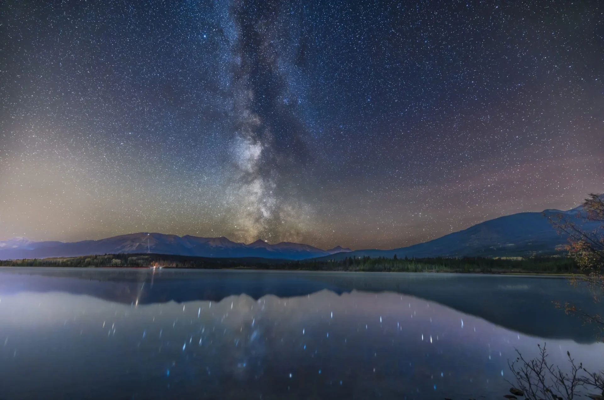 The Milky Way over and reflected in the relatively calm water of Pyramid Lake