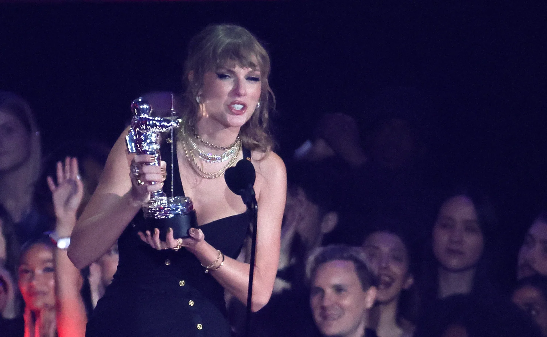 Taylor Swift posing with trophy.