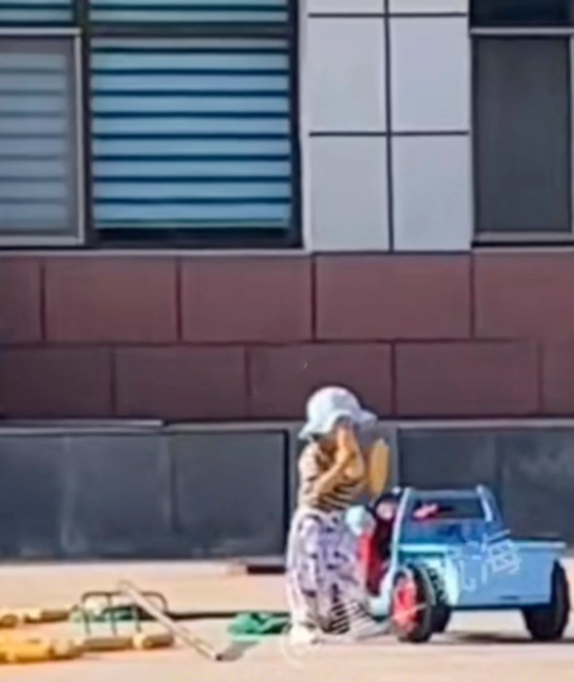 The toddler collects corn after it has dried in the sun, loading it onto his toy tractor to help his grandmother. Photo: Douyin.