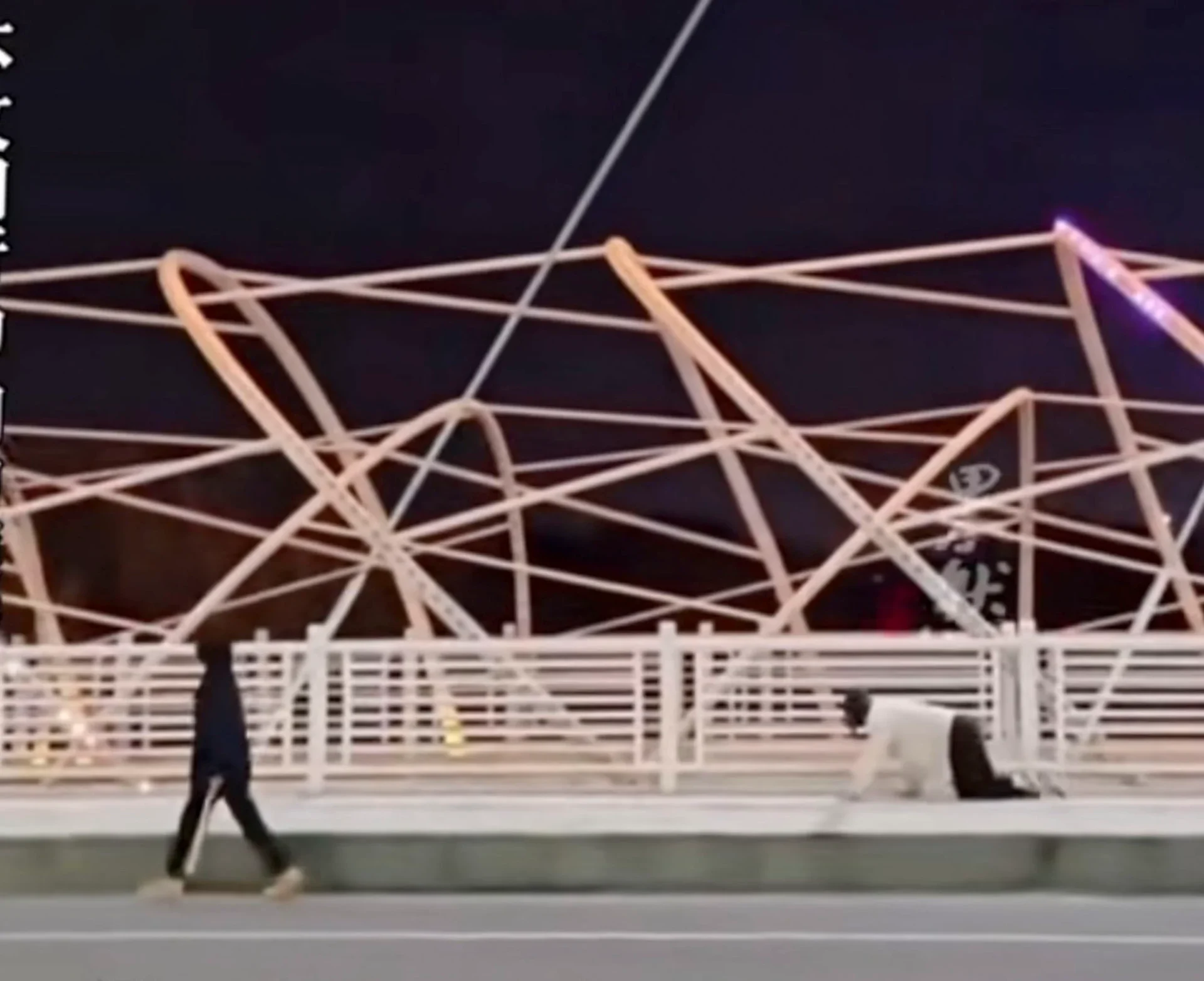 The man crawling along the bridge wearing dog headgear behind the woman. Photo: Douyin