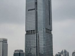 Vanke skyscraper with cracked foundation, muted cityscape.