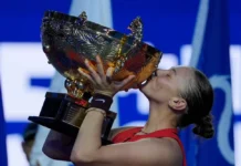 Anisimova wins China Open, holding trophy on court.