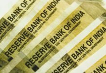 RBI Poised to Hold Rates Steady Amidst Trade Deal Easing Economic Pressure a stack of indian bank notes sitting on top of each other