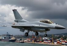 Peruvian F-16 jet flies over a busy port.