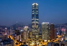 Luxury Hong Kong skyscraper at dusk with city lights.