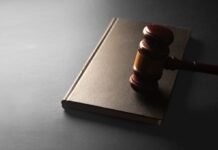 A wooden gavel rests on a closed book.