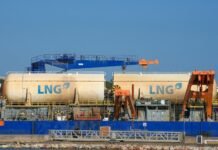 Two large lng tanks on a barge with cranes.
